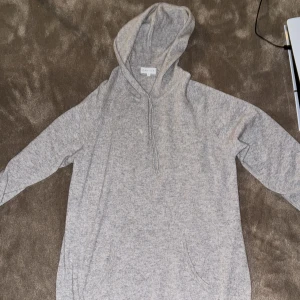 Cashmere hoodie  - Cashmere hoodie Davida i storlek L. Perfekt för kyliga dagar med sin mjuka och bekväma design. Den har en praktisk huva och långa ärmar.