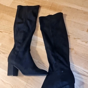 Svarta stövlar med klack - Snygga svarta stövlar med klack och spetsig tå. Perfekta för en stilren look. De är höga och ger en elegant touch till vilken outfit som helst.