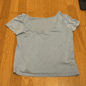 Ljusblå t-shirt - Säljer en enkel ljusblå t-shirt med korta ärmar och är backlessPerfekt för en avslappnad stil. Passar bra till jeans eller shorts. 