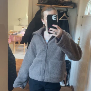 Brun teddyjacka med dragkedja - Mysig brun teddyjacka med dragkedja framtill. Använt fåtal gånger.Jackan har en hög krage och långa ärmar, perfekt för kyliga dagar.💓Kontakta mig vid intresse💓