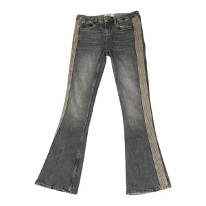 Jeans från bdg - Snygga jeans från BDG med unika randiga detaljer längs sidorna. De har en bootcut-stil som ger en retro känsla. Perfekta för att ge din outfit en cool touch. Tillverkade i Turkiet.