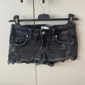 Svarta jeansshorts med slitningar - Snygga svarta jeansshorts. De har en knapp och dragkedja framtill samt klassiska fem fickor.💕💕💕