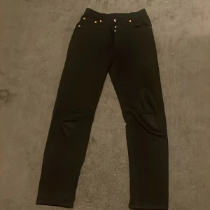 Svarta Levis 501 jeans - Snygga svarta Levis 501 jeans med klassisk design. De har en knappgylf och femficksmodell. Perfekta för en stilren look. Helst en snabb affär och kan diskuteras pris