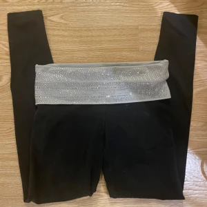 Svarta leggings från Victoria's Secret pink - Snygga svarta leggings från Victoria's Secret med en glittrig midja och texten 'PINK' i strass. Perfekta för yoga eller en avslappnad dag. De har en tight passform och är tillverkade i ett mjukt och stretchigt material. passar S och kanske M, ej flare