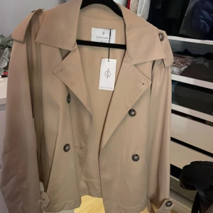 Trenchcoat  - En beige trenchcoat jag aldrig har använt 