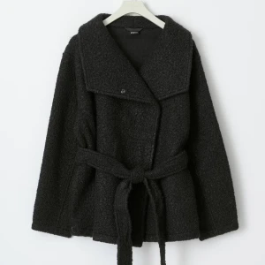 Svart kappa med bälte - Snygg svart kappa med bälte och bred krage. Perfekt för kyligare dagar med sin långa ärm och stilrena design. Ett måste i garderoben för den som gillar klassiska plagg. använd knappt, ganska oversized i storlek vilket inte passar mig längre. Inga defekter alls som ny! Ingen prislapp kvar sista bilden är tagen innan användning❤️