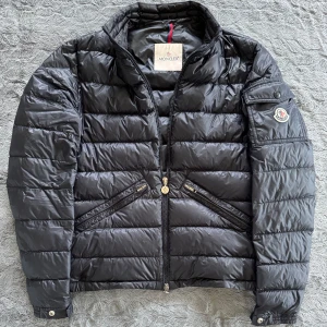  Moncler agay jacka  - Snygg mörkblå pufferjacka från Moncler i modellen agay med dragkedja och broderad logga på ärmen. Jackan har en quiltad design och praktiska fickor med knappar. Perfekt nu till våren😁. Den är i storlek 2 vilket passar s-m. Bara att höra av sig till oss vid minsta fundering☺️