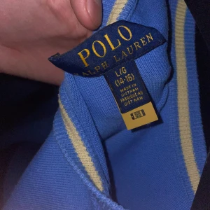Blå tröja från Polo Ralph Lauren - Säljer en stilren blå tröja från Polo Ralph Lauren med det klassiska logotypbroderiet på bröstet. Tröjan har långa ärmar och en rund halsringning. Perfekt för en avslappnad och snygg look. Passar runt 160