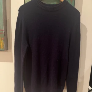 Mörkblå tröja från These Glory Days - Säljer en stilren mörkblå tröja från These Glory Days i storlek medium. Tröjan har en klassisk design med ribbad krage och långa ärmar, perfekt för kyligare dagar.