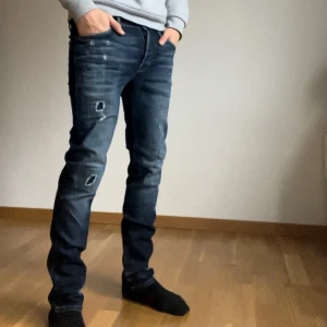 Mörkblå jeans från Jack & Jones - Snygga mörkblå jeans från Jack & Jones i slim fit. De har en klassisk femficksdesign och slitna detaljer för en trendig look. Perfekta för en avslappnad stil. Nypris på dessa är 1200kr! Skick 9/10 knappt använda.
