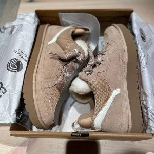 UGG Lowmel Sand - Trendiga UGG Lowmel sneakers i färgen Sand med mjukt foder och snörning. Skorna har en kombination av mocka och syntetmaterial, vilket ger en stilren look. Perfekta för kyligare dagar med sin varma insida. Helt oanvända! Tveka inte vid frågor!💫