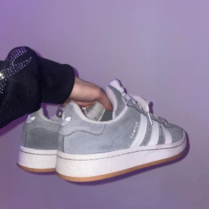 Grå Adidas Campus sneakers - Snygga grå Adidas Campus sneakers med klassiska vita ränder och snörning. Skorna har en stilren design med en bekväm gummisula. Perfekta för en avslappnad stil.🤍