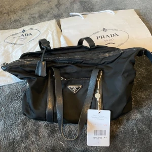 PRADA VÄSKA  - Köpt på Vestiare Collective med lappen kvar eftersom jag fick en liknande väska samtidigt som jag köpte! Perfekt vardagsväska🤍😶‍🌫️😌 Kommer med äkthetsbevis, dustbag, shopping påsen och lappen som hänger kvar på väskan från Vestiare!! Hör av er vid frågor, vad som helst!😙