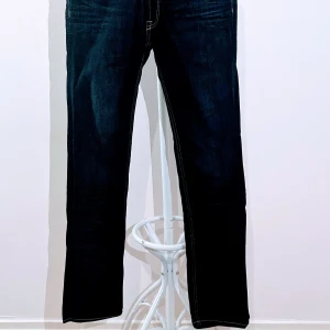 Mörkblå jeans från Dressmann  - Snygga mörkblå jeans från Dressmann i regular fit. Klassisk design med fem fickor och knappgylf. Perfekta för en stilren look.