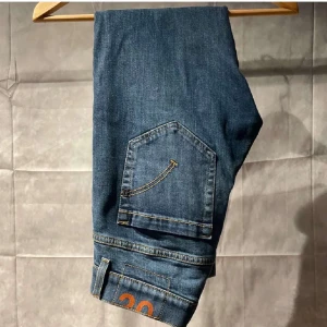 Dondup George  - Snygga blå jeansbyxor med en klassisk femficksdesign. De har en normal passform och är perfekta för en avslappnad stil. Byxorna har en diskret tvätt och är tillverkade i ett slitstarkt denimtyg.