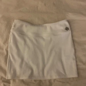 Vit kortkjol med blomma - Vit miniskirt med blomma på sidan 