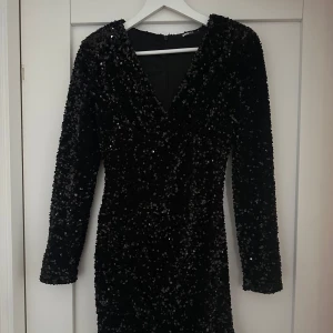svart glittrig nyårsklänning  - Snygg svart klänning från gina tricot med glittrande paljetter och en v-ringad design. Perfekt till nyår eller annan fest!🙌🏻 endast använd en gång!!