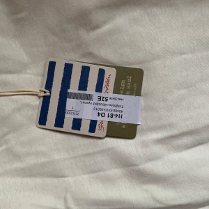 Vit klänning från Saint James - Säljer en stilren vit topp från Saint James. Toppen har en enkel design med rund hals och ärmlös stil, perfekt för varma dagar. Materialet känns mjukt och bekvämt mot huden.