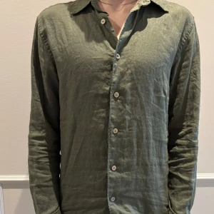 Linneskjorta - Tvärsnygg olivgrön linneskjorta från Uniqlo. Köpt i somras. Säljs pga av att den har blivit för liten. 100% linne och passar som sagt både till jeans eller ett par sköna shorts. Storlek XS, tveka inte att höra av dig vid minsta fundering. 