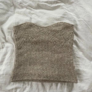 Beige stickad tubtopp - Säljer en stilren beige stickad tubtopp. Perfekt för lager-på-lager eller som den är. Den har en ribbad struktur som ger en snygg passform.