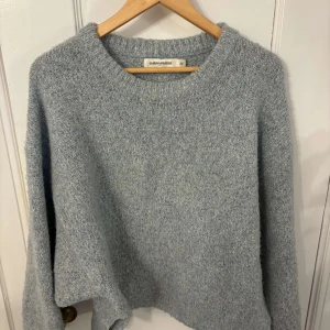 Ljusblå stickad tröja från Carin Wester - Mysig ljusblå stickad tröja från Carin Wester. Perfekt för kyliga dagar med sin mjuka och bekväma passform. Tröjan har långa ärmar och en rund halsringning.