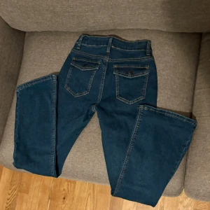 Blå jeans - Helt nya, oanvända. Skit Snygga blå jeans med bakfickor med lock.. storlek XS. Lagom utsvängda nertill. Säljer vidare då min dotter tyckte dom var för precis i längd på henne. Hon 169cm. Så är man kring 165cm borde dom bli helt perfekt 👌 