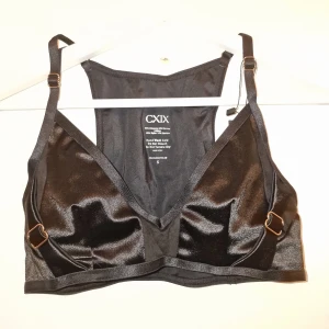 Svart satin bralette från CXIX - Snygg svart bralette i satin från CXIX med justerbara axelband och trekantsformade kupor. Perfekt för en stilren och bekväm look. 🖤 Garderobsrensning så kika gärna på övriga auktioner.