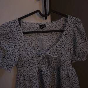 Blommig blus med knytning - Topp från Gina tricot storlek XS                   ALDRIG ANVÄND! 