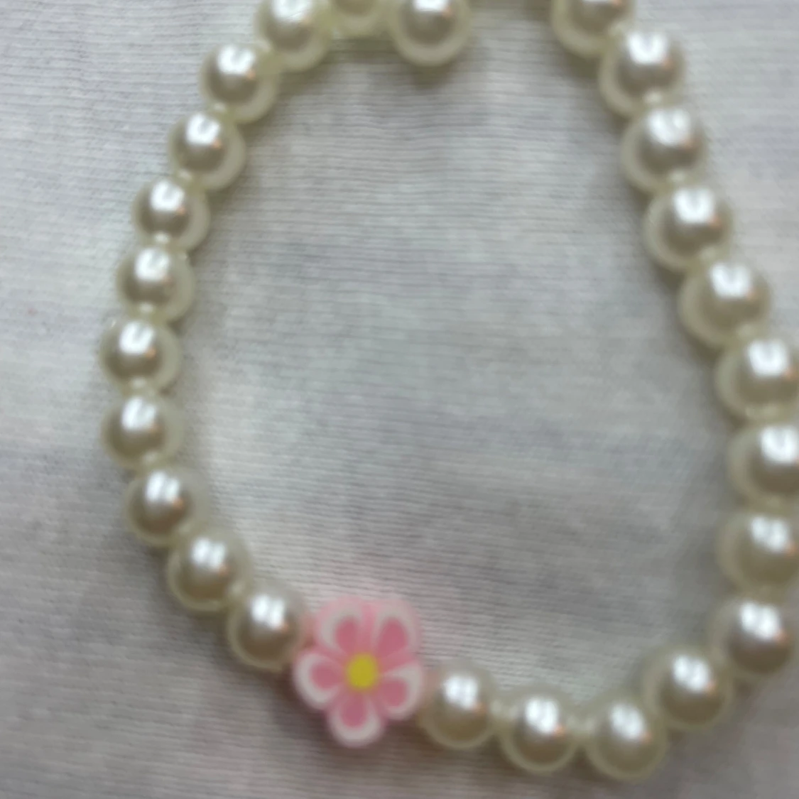 Pärlarmband med rosa blomdetalj