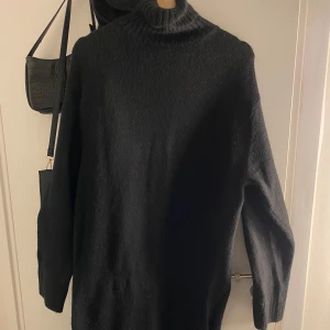 Svart polotröja - Säljer en stilren svart stickad klänning i mycket bra skick. Perfekt för kyliga höst- och vinterdagar. Klänningen har långa ärmar och en bekväm passform som håller dig varm och snygg. Ett måste i garderoben för alla som älskar stickade klänningar😍😍