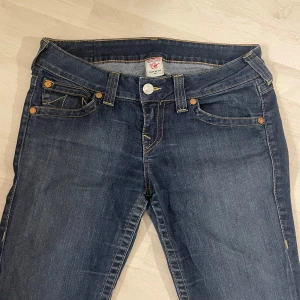 Mörkblå jeans  True Religion - Säljer ett par snygga mörkblå jeans från True Religion. Passar mig perfekt som är 166 cm lång. 40 cm tvärs över, innebenslängd 74 cm.  Betalning sker via Swish, kontakta mig om du har några frågor. Perfekta för både vardag och fest!