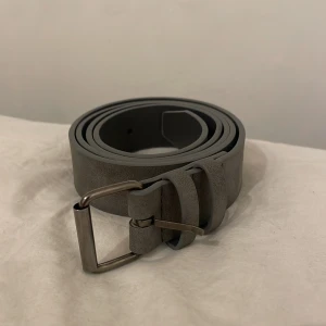Grått bälte  - Säljer ett snyggt grått bälte. Skriv vid funderingar🔥🔥Har haft det 1 gång så det är så gott som nytt🔰