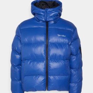 Blå pufferjacka från Night Addict - Säljer en snygg blå pufferjacka från Night Addict. Den är perfekt för kalla dagar med sin tjocka vaddering och har en praktisk dragkedja framtill. Jackan har en hög krage och är långärmad, vilket gör den idealisk för både höst och vinter. Den är i mycket bra skick och redo för nya äventyr! Kontakta mig för frågor eller fler bilder!