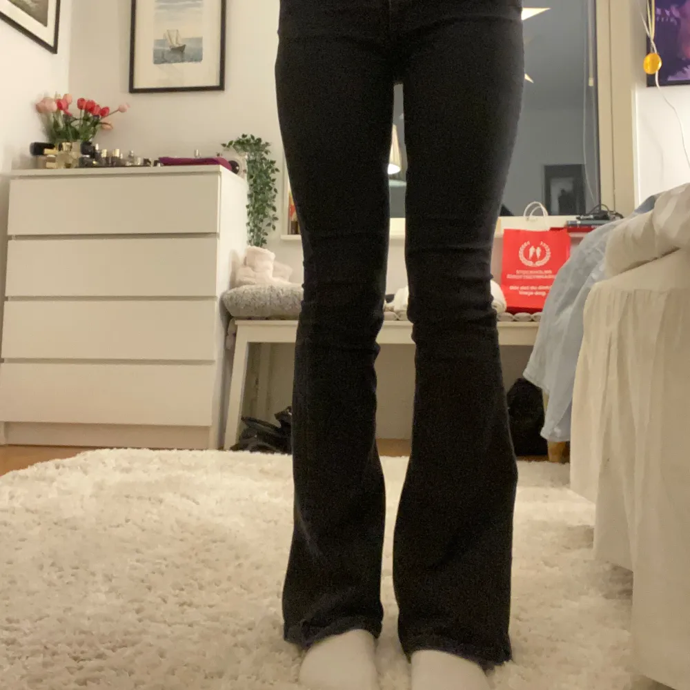 Säljer ett par svarta bootcut jeans i mycket bra skick. De är lågmidjade och har en klassisk femficksdesign med knappar och dragkedja. Perfekta för både vardag och fest! 🖤från STR. Jeans & Byxor.