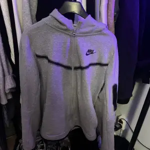 Säljer en grå hoodie från Nike i storlek XL. I barn Den har en dragkedja framtill och en klassisk Nike-logga på bröstet. Perfekt för både träning och vardag. Hoodien är i mycket bra skick och superbekväm att ha på sig. Passar perfekt till höst och vår!