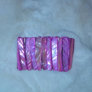 Rosa glittrigt armband - Snyggt rosa armband med glittrig yta som reflekterar ljuset superfint. Perfekt för att piffa upp vilken outfit som helst, oavsett om det är till vardags eller fest. Armbandet har en flexibel passform och är lätt att bära hela dagen.