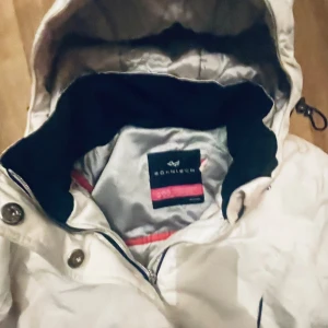Vit parkajacka från Röhnisch - Säljer en snygg vit parkajacka från Röhnisch i mycket bra skick. Jackan har en hög krage och en praktisk huva. Den är långärmad med knappar och dragkedja framtill. Perfekt för kyliga höst- och vinterdagar. Storlek dam 38