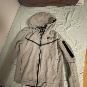  Nike tech kofta grå  - Säljer en Nike tech fleece från Nikes hemsida. Den är sparsamt använd så skick 9/10. Priset är inte hugget i sten. Kom privat för övriga frågor😁