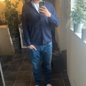 Mörkblå skjorta från Uniqlo - Säljer en stilren mörkblå skjorta från Uniqlo i storlek M. Skjortan är i mycket bra skick, använd någon gång