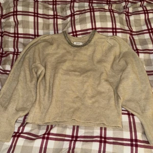 Beige tröja från ONLY - Säljer en superfin beige tröja från ONLY i storlek M. Den har långa ärmar och en snygg pärldetalj runt halsringningen som ger en extra touch. Perfekt för både vardag och fest! 🥰
