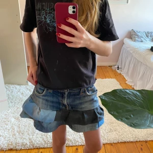 Jeanskjol med volangdetaljer - Säljer en superfin jeanskjol med volangdetaljer i olika blå nyanser som jag sytt själv. Kjolen har en klassisk femficksdesign och är perfekt för sommardagar. Den är i bra skick och har en cool, avslappnad stil. Passar perfekt till en t-shirt eller en söt topp! Midjemått: 40 cm rakt över