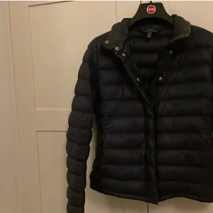 Mörkblå jacka från Polo Ralph Lauren - Säljer en snygg mörkblå dunjacka från Polo Ralph Lauren i storlek XL. Jackan har en stilren design med dragkedja och knappar framtill. Perfekt för kyliga höst- och vinterdagar. Den är i mycket bra skick och redo för nya äventyr! 🧥✨