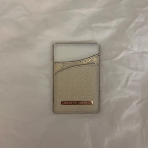Beige kortfodral från Ideal of Sweden - Säljer en magnetisk korthållare från ideal of sweden!! Denna korthållaren är magnetisk och går att sätta på ideal of sweden skal (eller andra magnetiska skal) går även bra att bara lägga i väskan! Korthållaren har 2 fack men får plats med flera kort. Den är oanvänd!