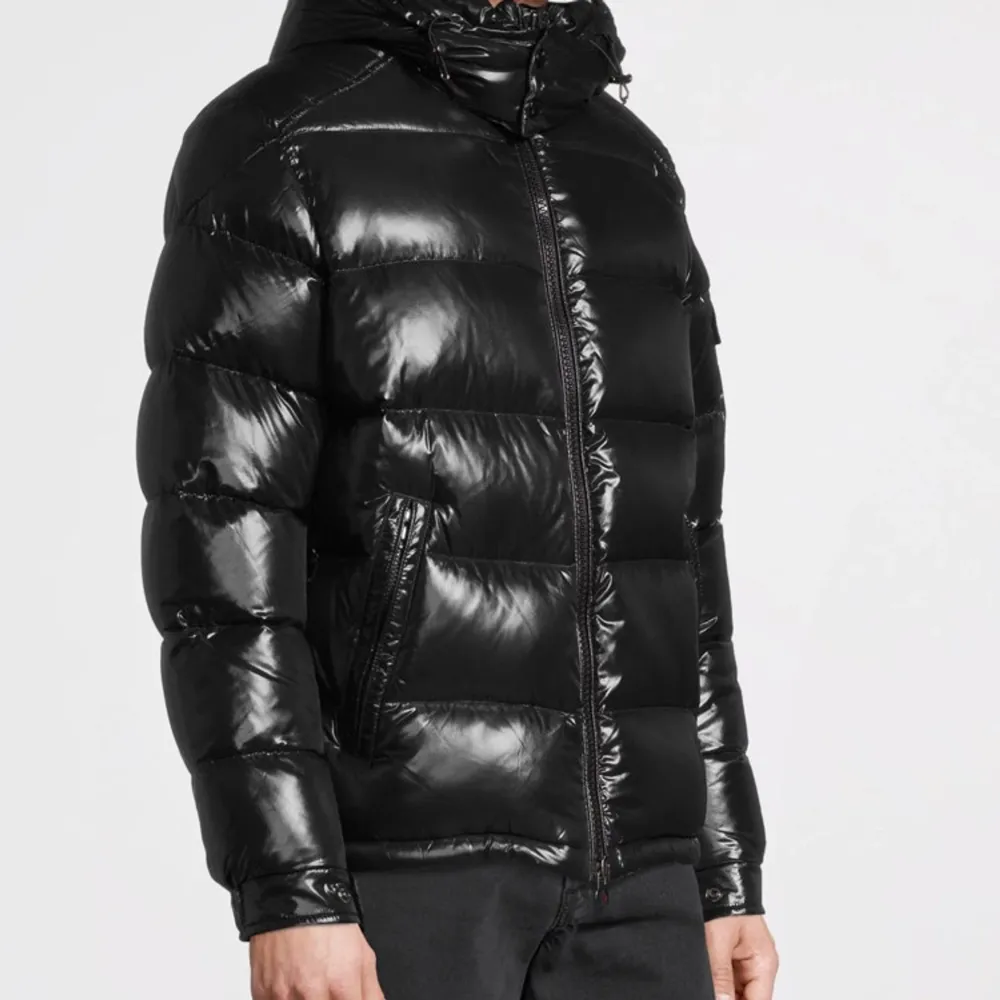 Säljer en snygg svart pufferjacka från Moncler i mycket bra skick. Jackan har en glansig finish och är perfekt för vintern. Den har en dragkedja framtill och långa ärmar. Moncler-loggan är broderad på bröstet. Perfekt för att hålla sig varm och stilren under kalla dagar!. Jackor.