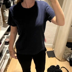 Gant - Säljer en enkel och stilren mörkblå t-shirt i bomull. Den har en normal passform och korta ärmar, perfekt för vardagsbruk. T-shirten är i bra skick och passar till det mesta i garderoben. Perfekt för både vår och sommar