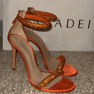 Casadei satin klackar - Otroligt fina klackskor från Casadei med glittrande detaljer. Klackhöjd 10 cm.  Använda 3 gånger, har ett litet hack i ena klacken men som går att fixa till, annars väldigt fint skick. Nypris 9210kr, mitt pris 6500kr. Inköpta oktober, kvitto finns och kartong och påse medföljer🧡