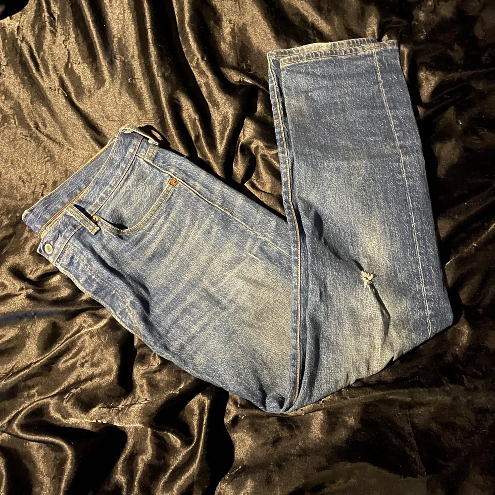 Säljer ett par klassiska blå Levi's jeans i modell 501. De är i bra skick med en liten slitage på ena benet för en cool look. Perfekta för både vardag och fest! Passar till allt och är superbekväma. 🕺slitaget är original och inte riktiga.. Farkut & Housut.