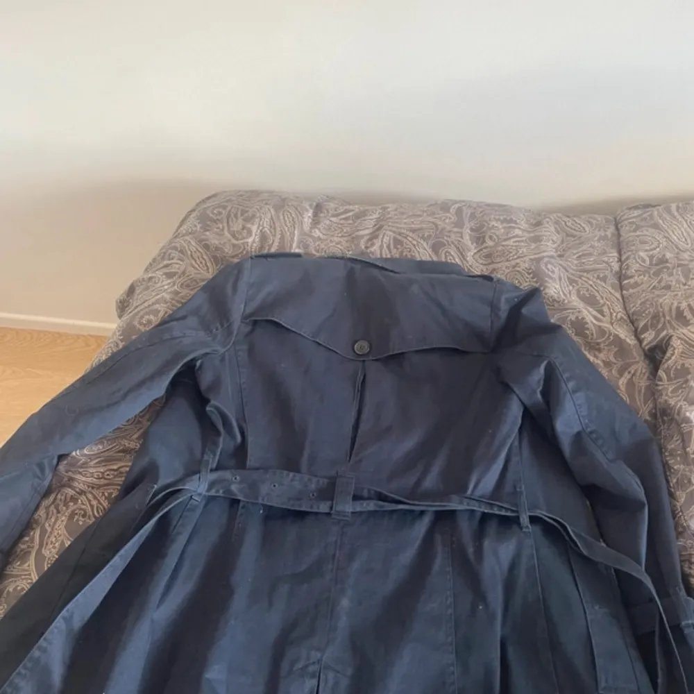 Säljer en snygg mörkblå trenchcoat från Esprit. Den har klassiska knappar och ett bälte i midjan för en stilren look. Perfekt för höst och vår! 🧥. Takit.