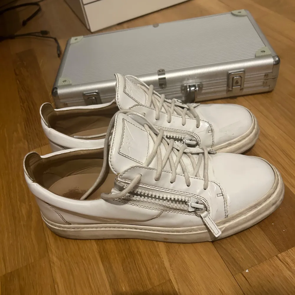 Säljer ett par vita sneakers i bra skick, ända som saknas är den där vita grejen på dragkedjan på ena som ni ser på bilden, tar även emot byten. Endast skorna tillkommer. Skorna har en stilren design med en bekväm passform.. Skor.