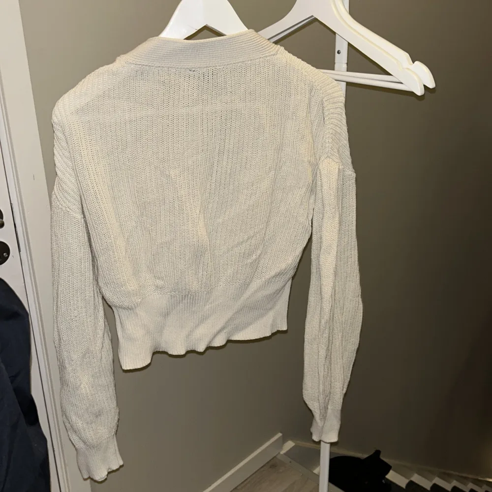 Säljer en superfin beige stickad kofta från Lindex i storlek S. Den har stora knappar framtill och en croppad passform som är perfekt för både höst och vår. Koftan är i mycket bra skick och är riktigt mysig att ha på sig. Perfekt för lager-på-lager-stil! 🍂✨. Neuletakit & Villapaidat.